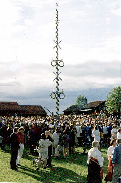 A maypole in the middle of a crowd