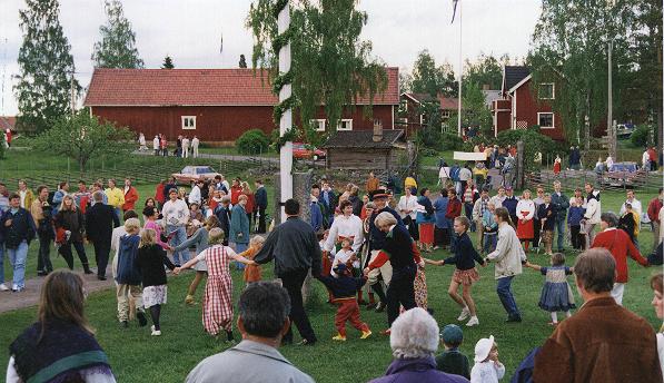 People dancing ring dances around the maypole