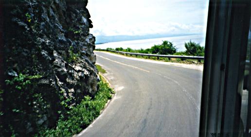 Narrow road with mountain on one side and the sea on the other