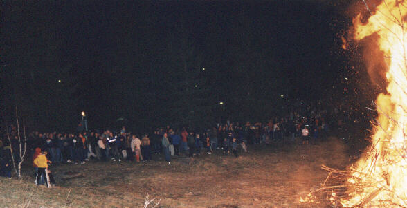 A crowd standing around the fire